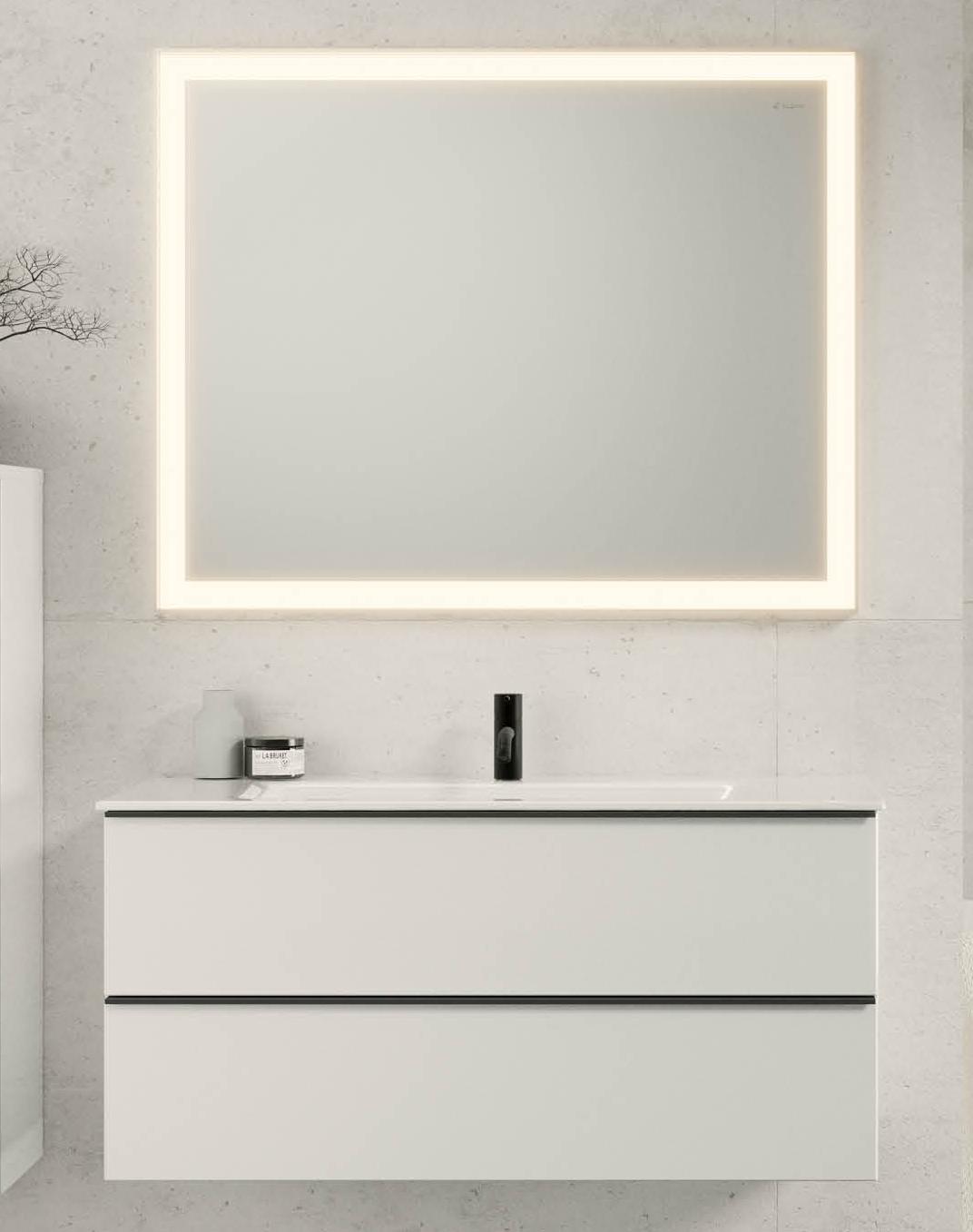 Modernes Badezimmer mit beleuchtetem Spiegel, integriertem Möbelwaschtisch und schwarzer Armatur.
