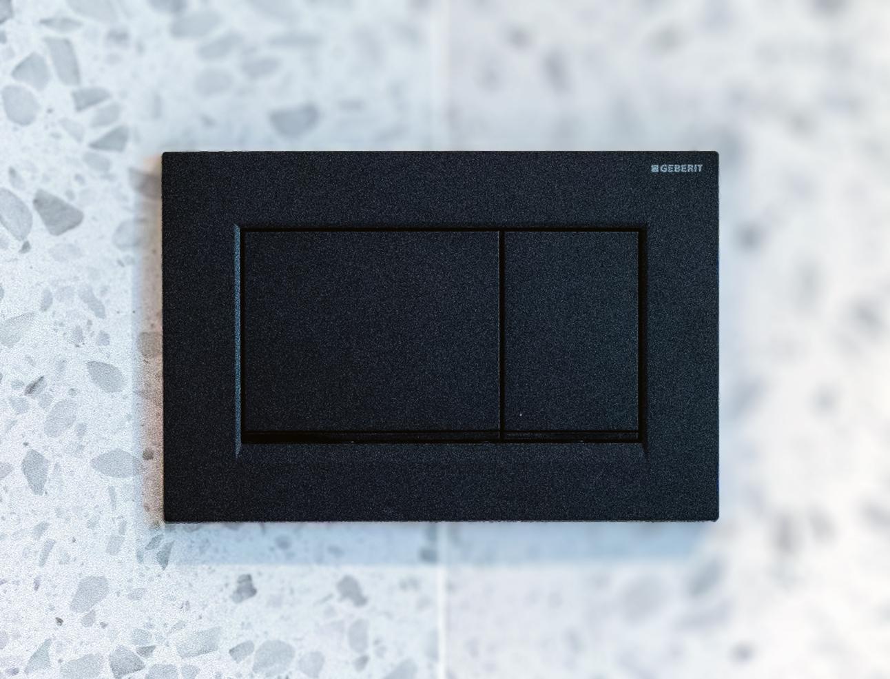 Moderne schwarze Betätigungsplatte von Geberit für WC-Spülung.